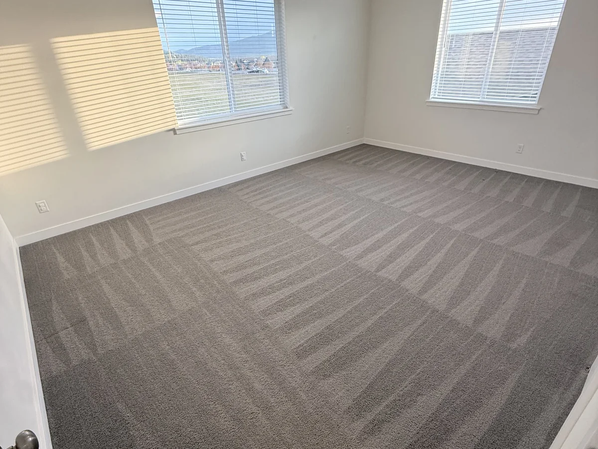 Empty carpeted room cleaned for a move-out handoff
